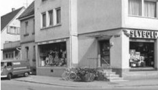 Altstadtbild mit Einkaufsstraße: Geschäft Elektro Seybold, Auto und Fahrrad – typische urbanes Leben.